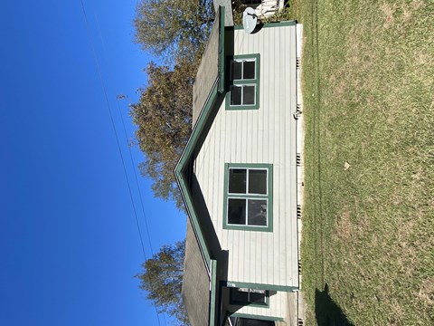 a view of the top of a house in the middle of a field