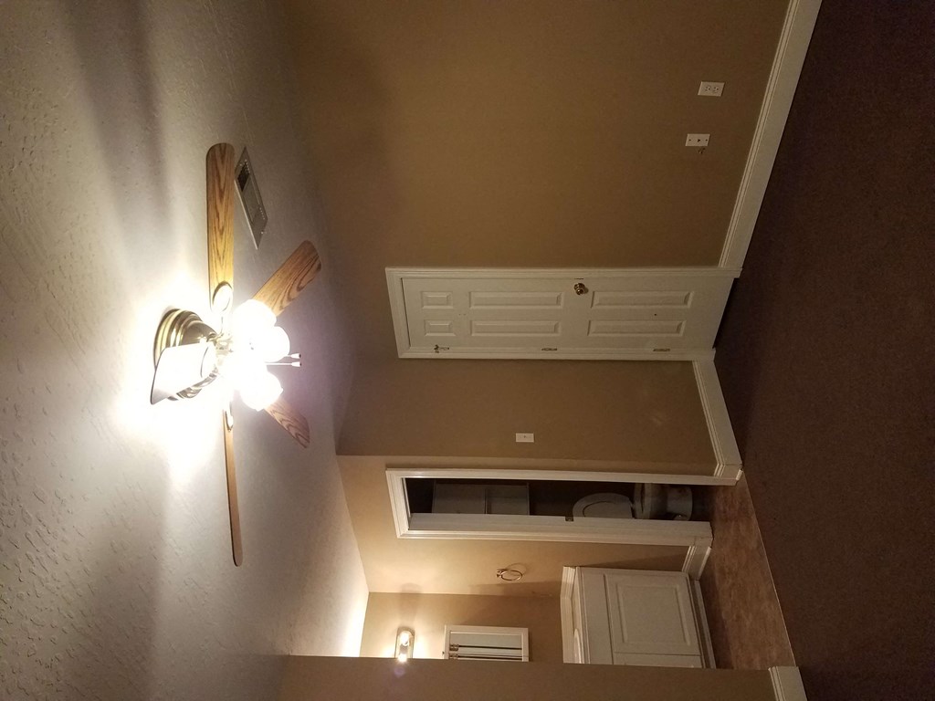a room with a ceiling fan and a kitchen with a sink