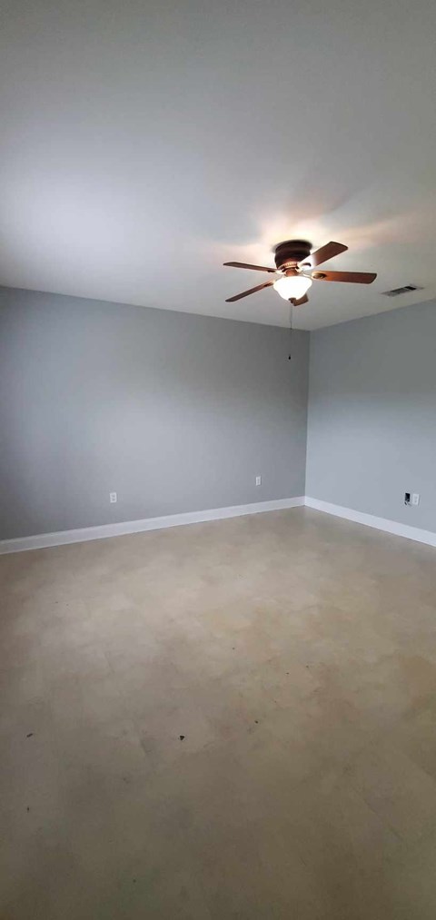 A room with a ceiling fan and a light on.