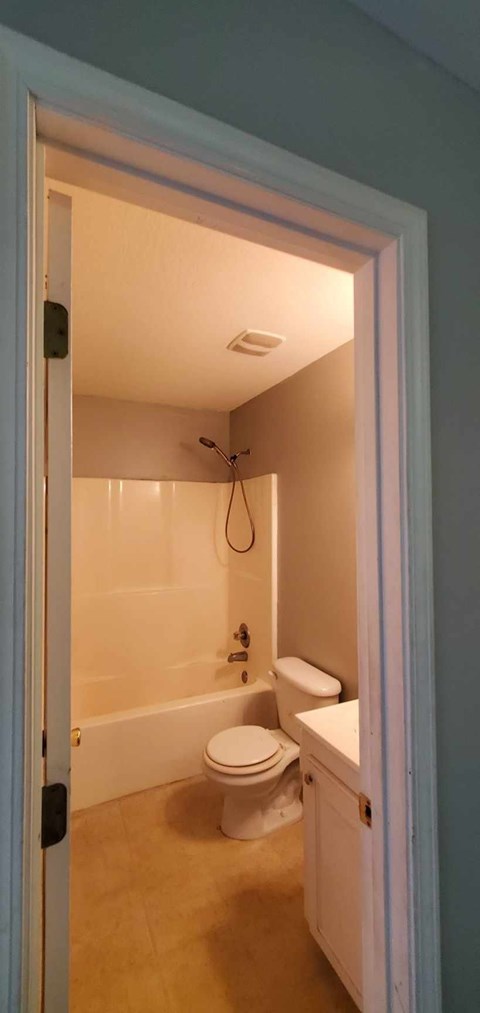 A bathroom with a toilet, sink, and bathtub.