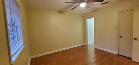 a living room with wood floors and a ceiling fan