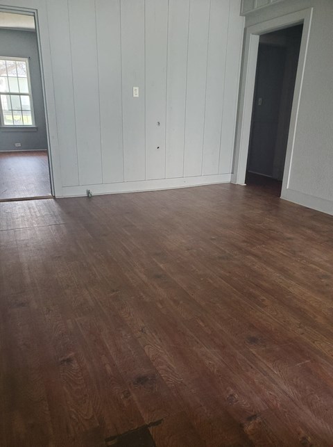a living room with white walls and a wooden floor