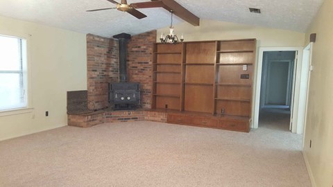 a living room with a fireplace and a book shelf