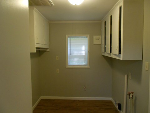 a kitchen with white cabinets and a window