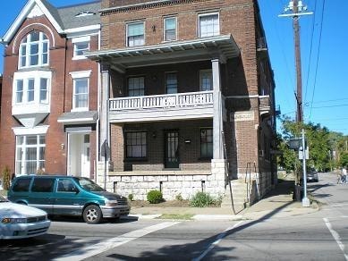 a building on the corner of a street with a car