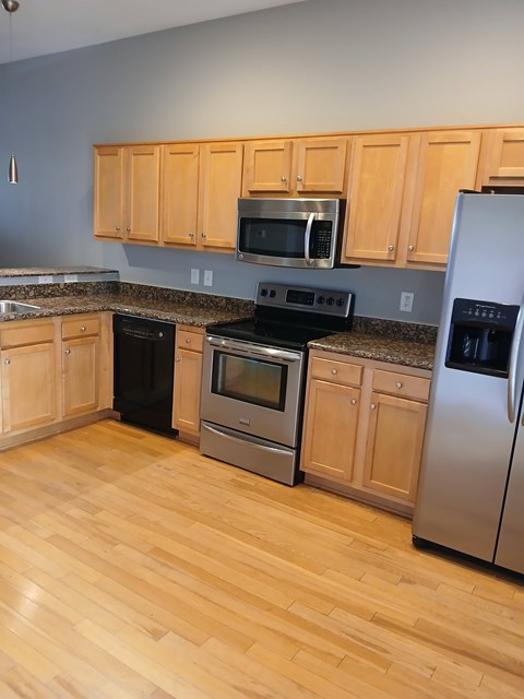 A kitchen with wooden cabinets and stainless steel appliances.