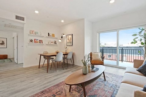 a living room and dining room with a balcony