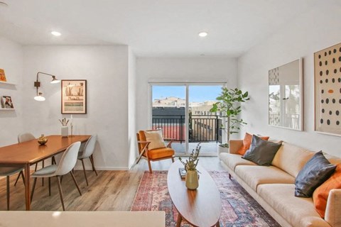 the living room and dining area of an apartment with a couch and a table
