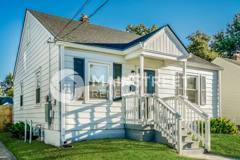 a small white house with a porch and stairs