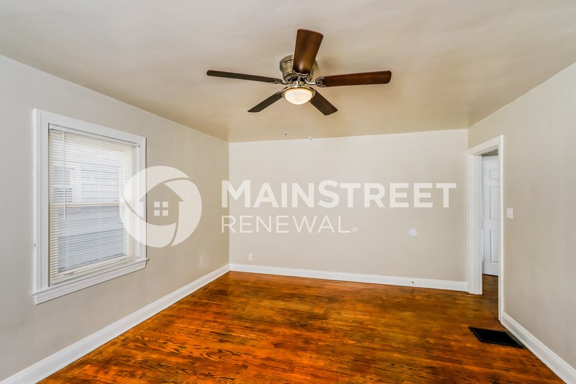 a living room with a wood floor and a ceiling fan