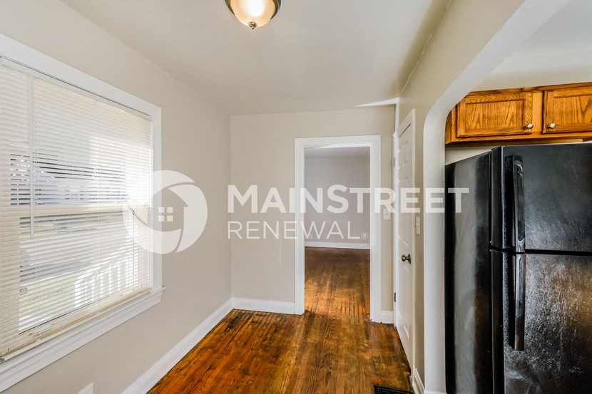 a kitchen with a large window and a black refrigerator