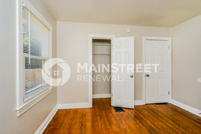 a bedroom with a closet and a window and a door