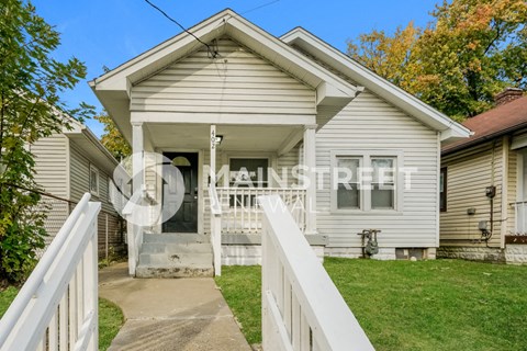 a small white house with a white fence and grass