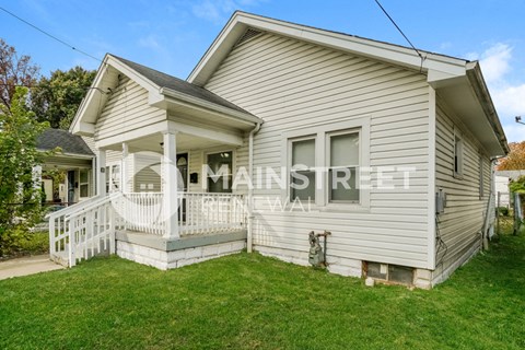 a white house with a porch and a lawn