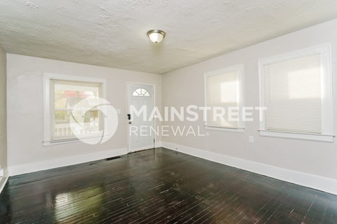 a living room with wood floors and white walls
