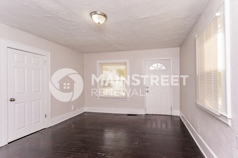 a clean and empty living room with a white door