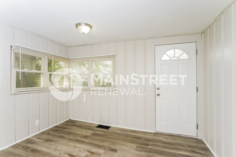 a small white room with a white door and a window