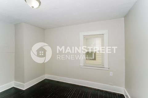 a small room with a white wall and a window