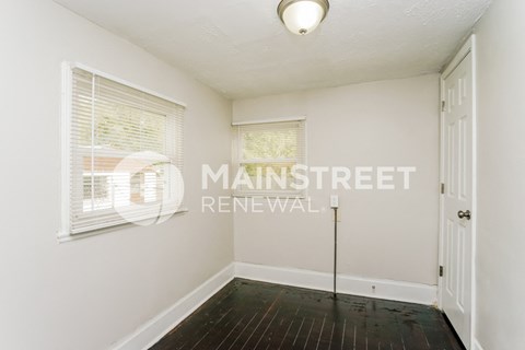 a small white room with a white door and a window