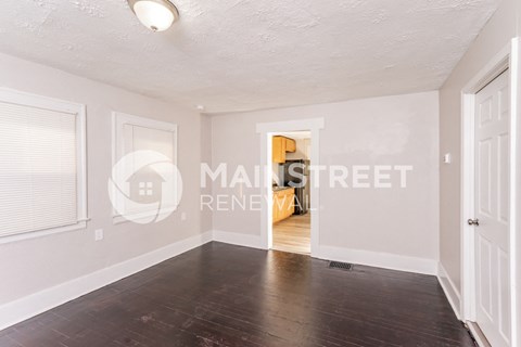 a renovated living room with wood floors and white walls