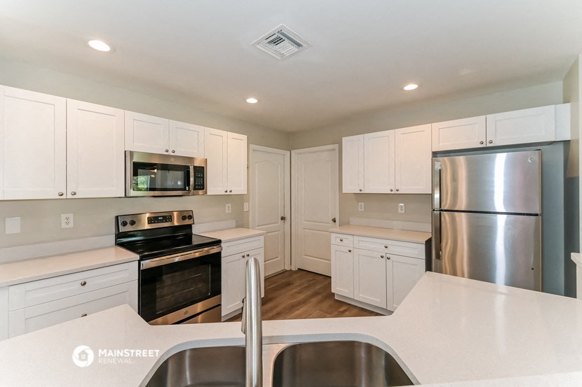 a kitchen with white cabinets and stainless steel appliances