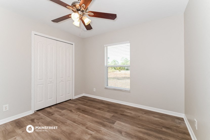 the living room of a home with a ceiling fan and a window
