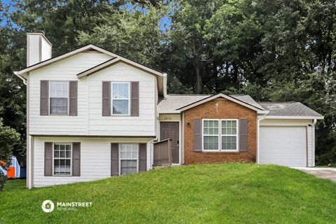 a white house on a hill with a garage