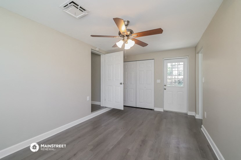 the living room of an empty house with a ceiling fan