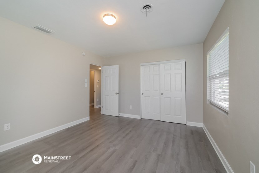 the spacious living room with white doors and wood flooring