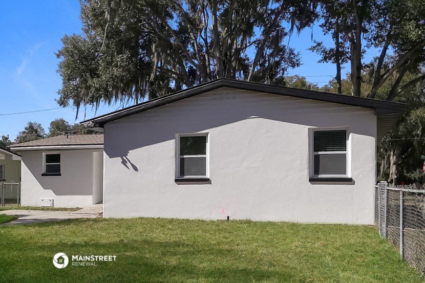 a white house with two windows on the side of it