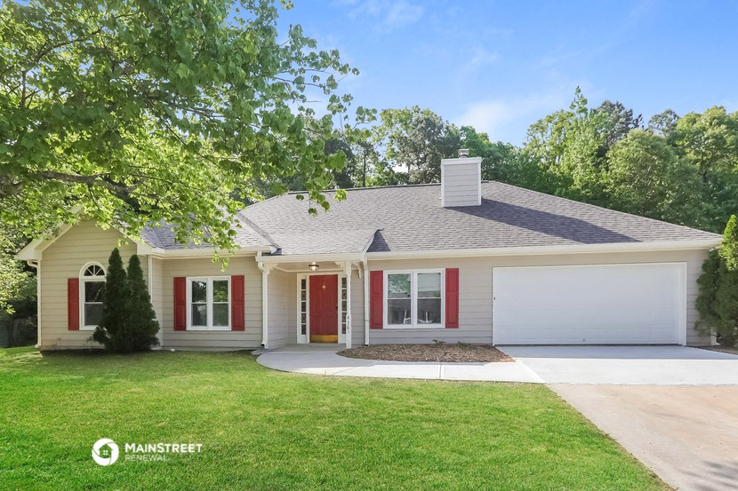 a white house with red shutters and a lawn