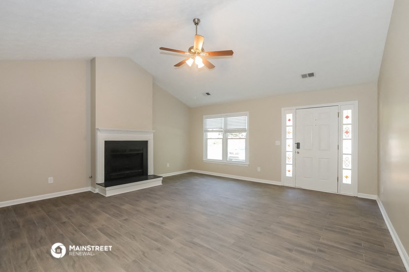 the living room with fireplace and ceiling fan