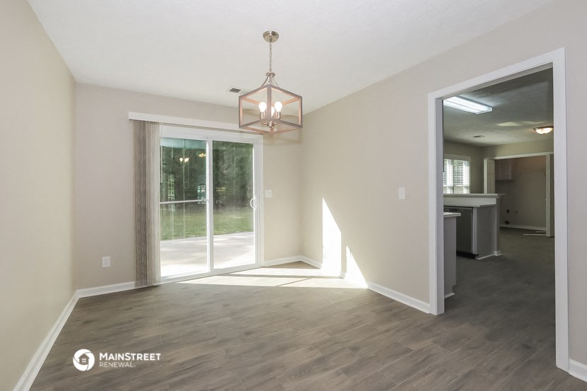 the living room of a new home with a large window and a chandelier