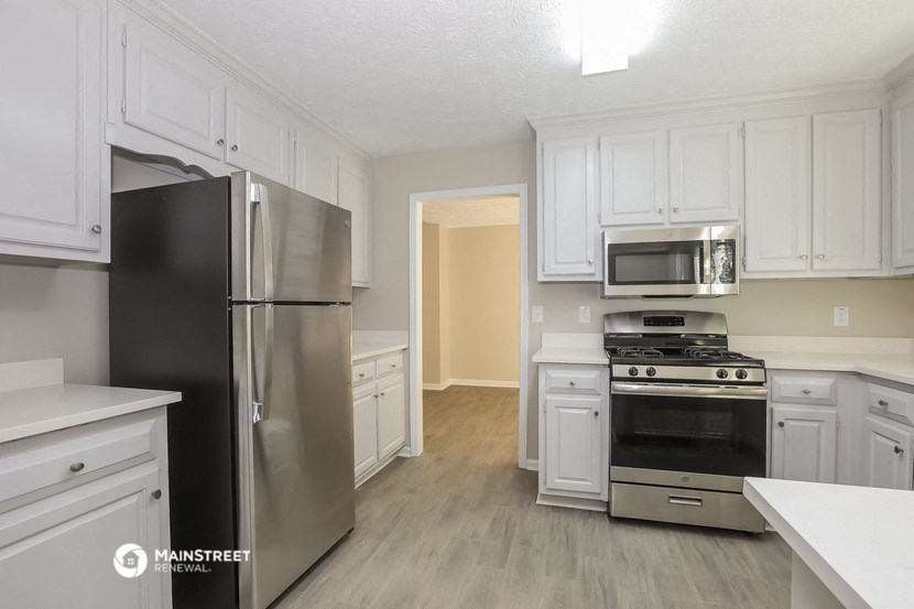 a white kitchen with stainless steel appliances and white cabinets
