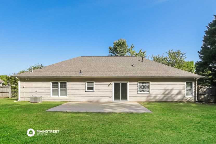 the front of a white house with a yard and grass
