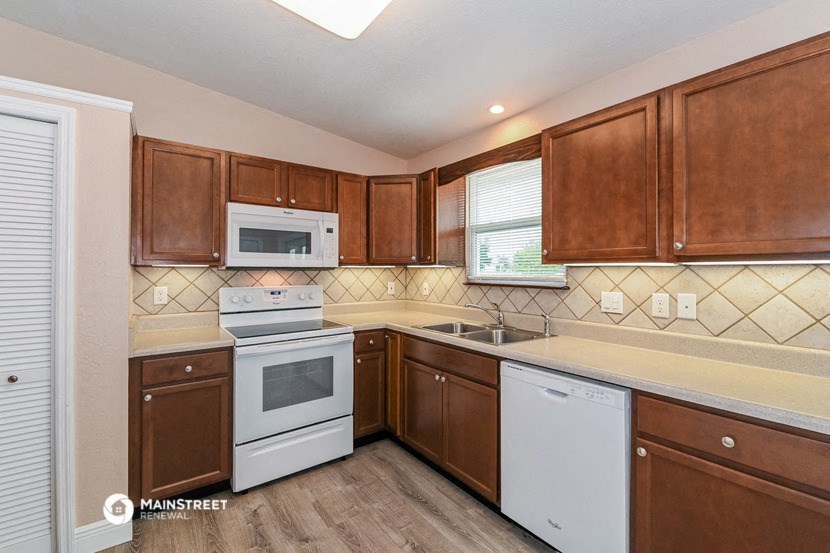a kitchen with white appliances and wooden cabinets