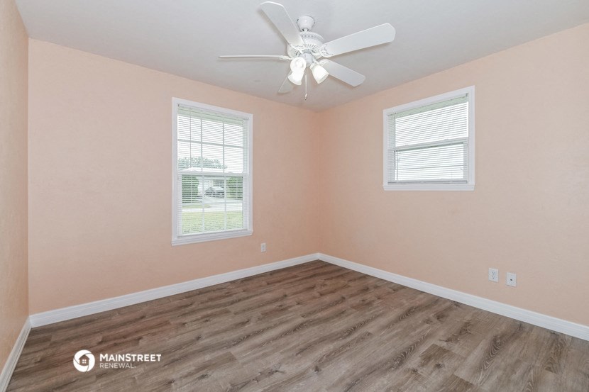 the bedroom with wood flooring and a ceiling fan