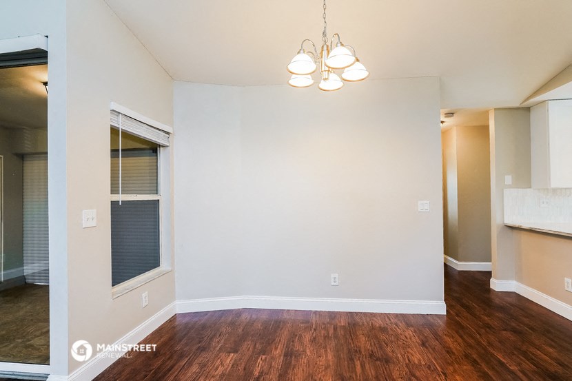 an empty living room with wood flooring and a window