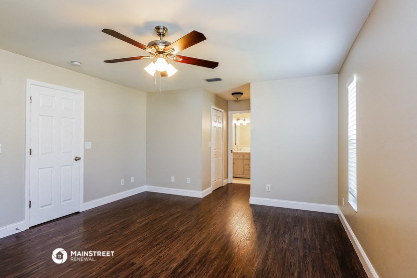 the living room of an empty house with a ceiling fan