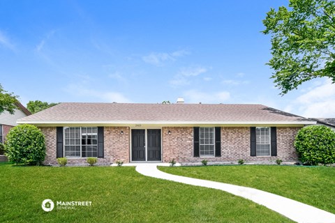 a home with a lawn and a sidewalk in front of it