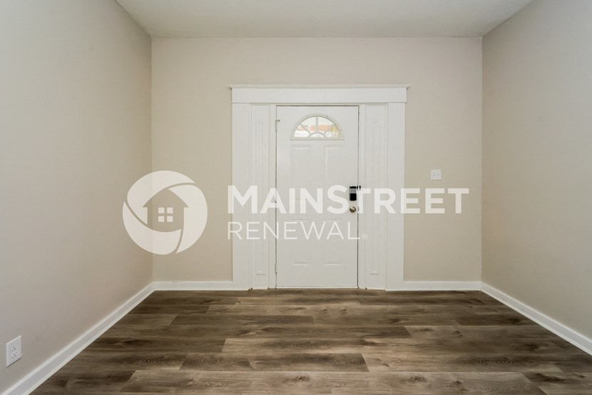a room with a white door and vinyl flooring
