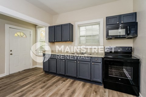 a kitchen with black cabinets and a stove and a microwave