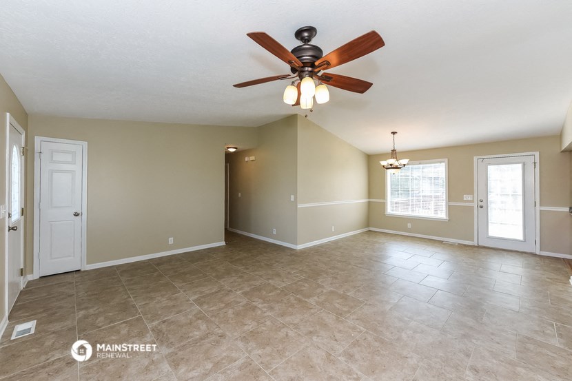 the spacious living room with ceiling fan and tile flooring