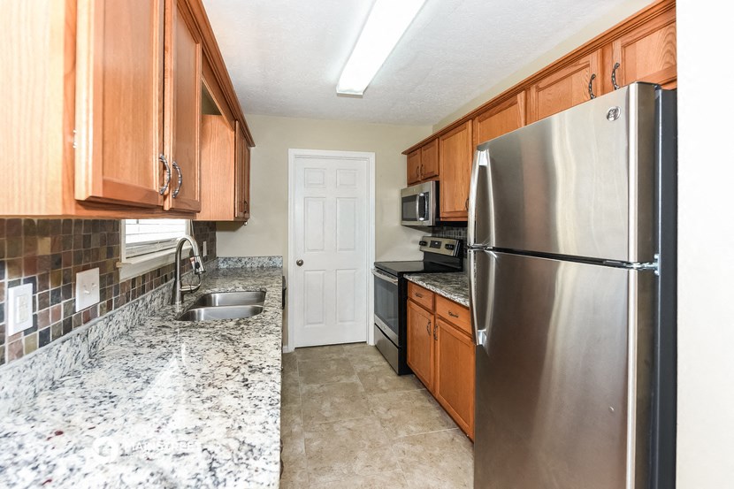 a kitchen with stainless steel appliances and wooden cabinets