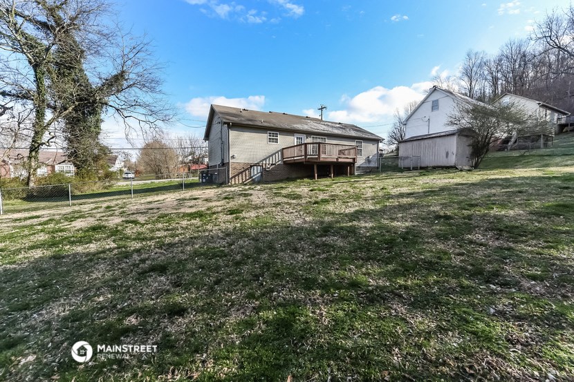 the backyard of a house with a yard and a deck