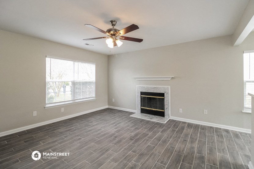 the living room with fireplace and ceiling fan