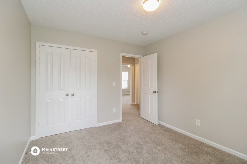 a bedroom with two closets and a door to a hallway