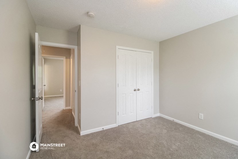 a bedroom with a closet and a door to a hallway