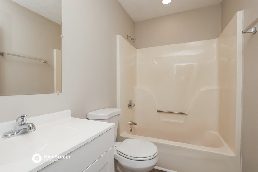 a bathroom with a toilet and a sink and a bath tub