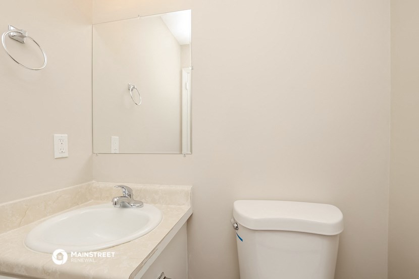 a bathroom with a sink and a toilet and a mirror